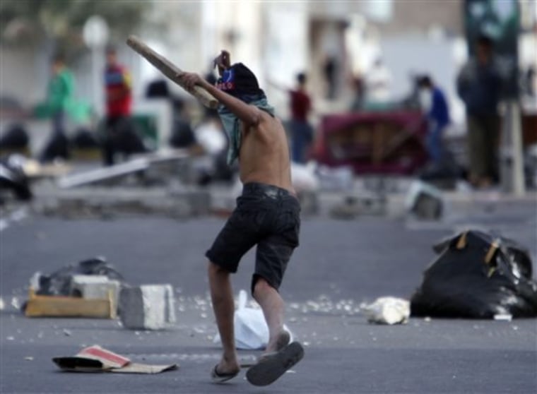 A Shiite Bahraini youth holds a piece of wood in the streets of Malkiya, Bahrain, Wednesday, March 16, 2011, where he and others hauled out debris for barricades and found sticks to use as clubs in preparation for government-supporting forces they expect will role into their Shiite Muslim village southwest of the capital of Manama. (AP Photo/Hasan Jamali)